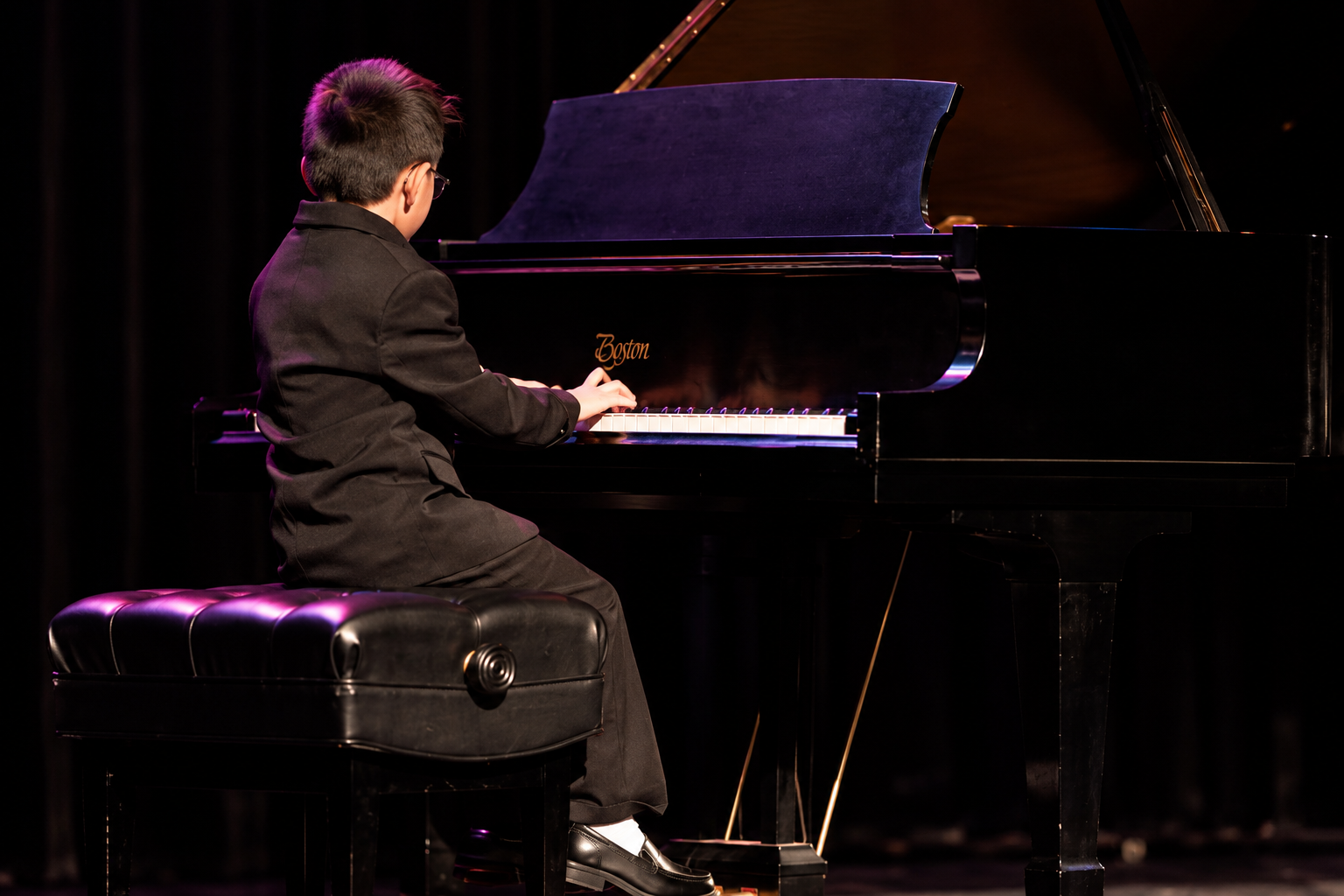 Pianist beside the raised lid of a grand piano · MBMS archive