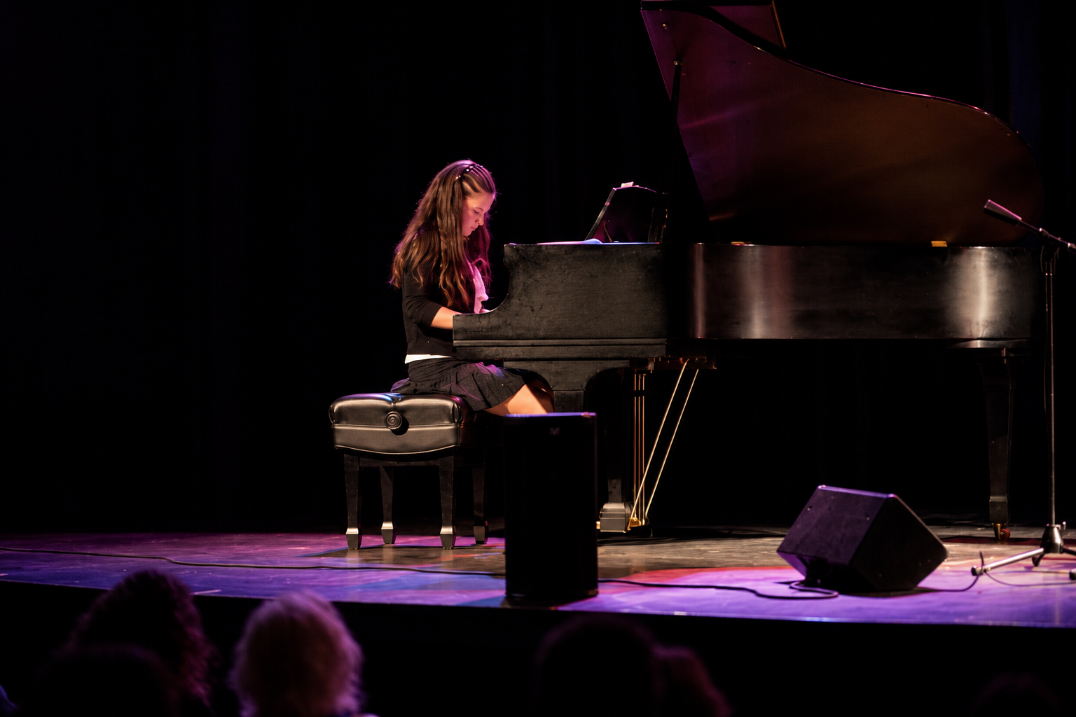 Pianist performing on a darkened stage · MBMS archive