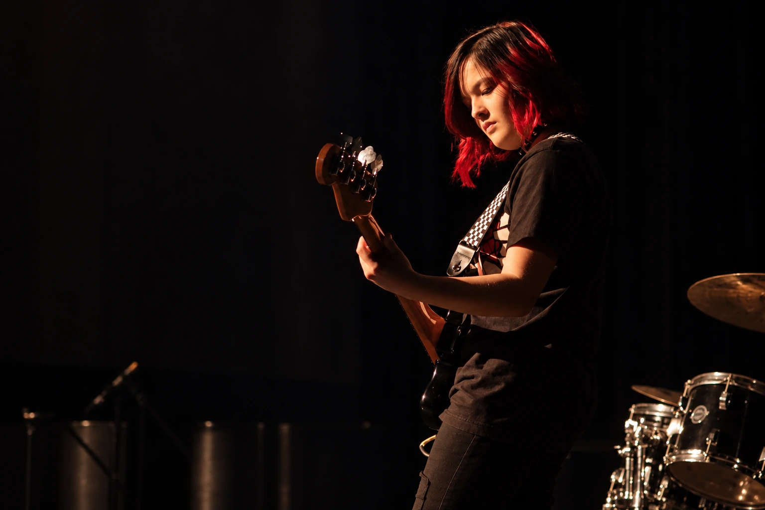 Teen musician playing bass on an MBMS stage