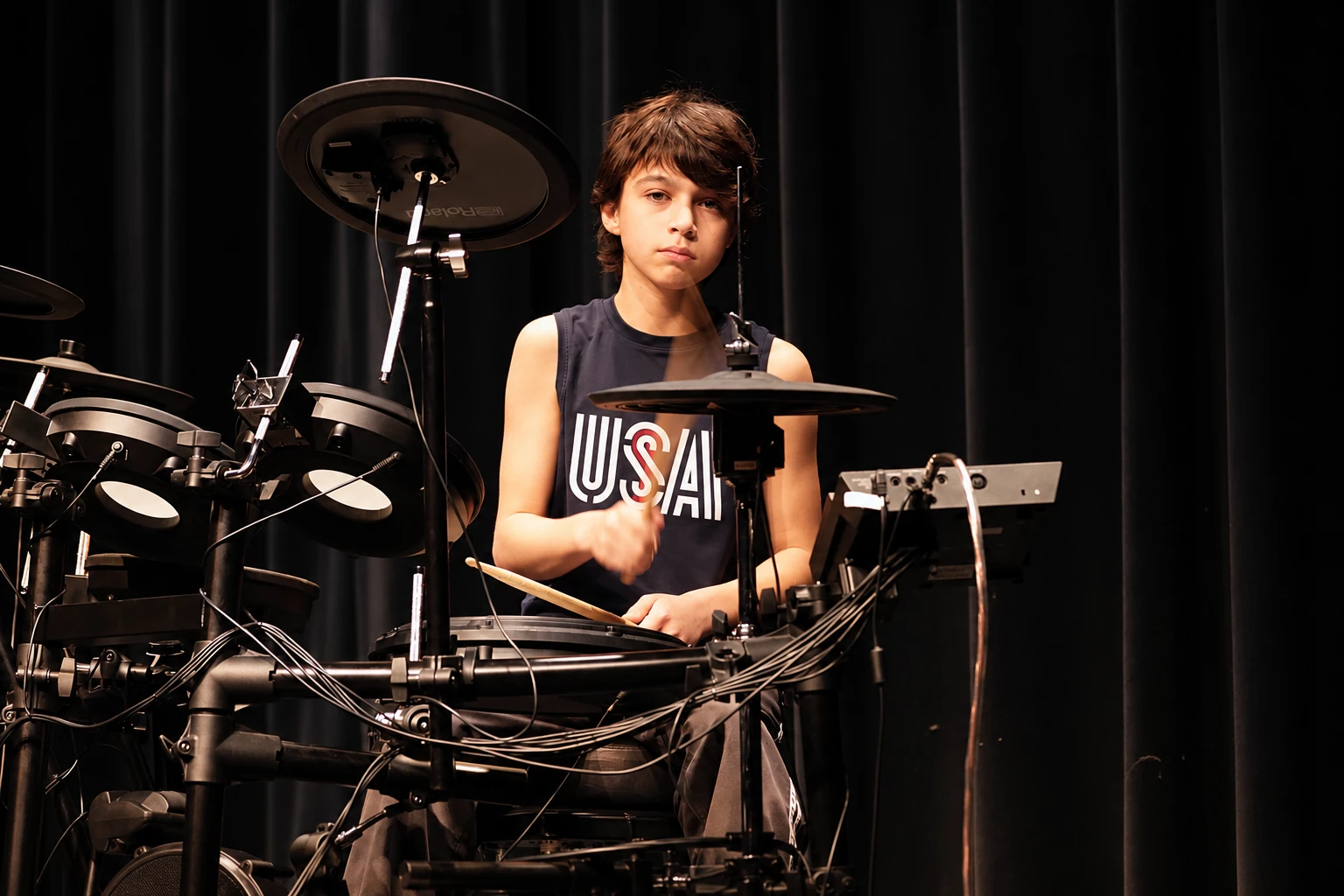 Student drummer performing at an electronic drum kit