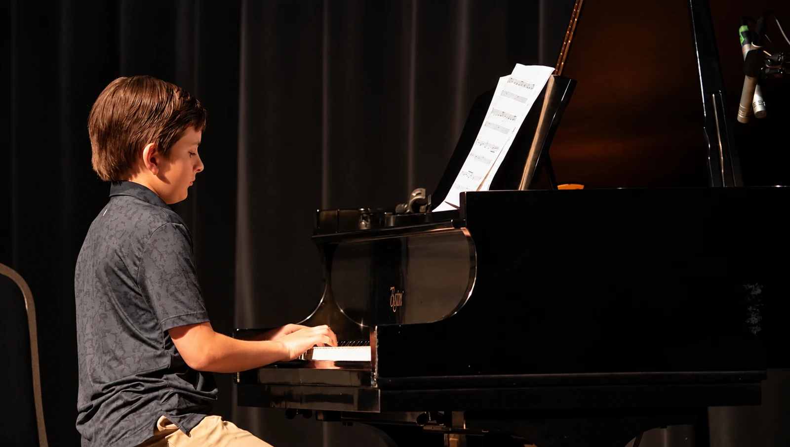 Teen musician playing piano on an MBMS stage