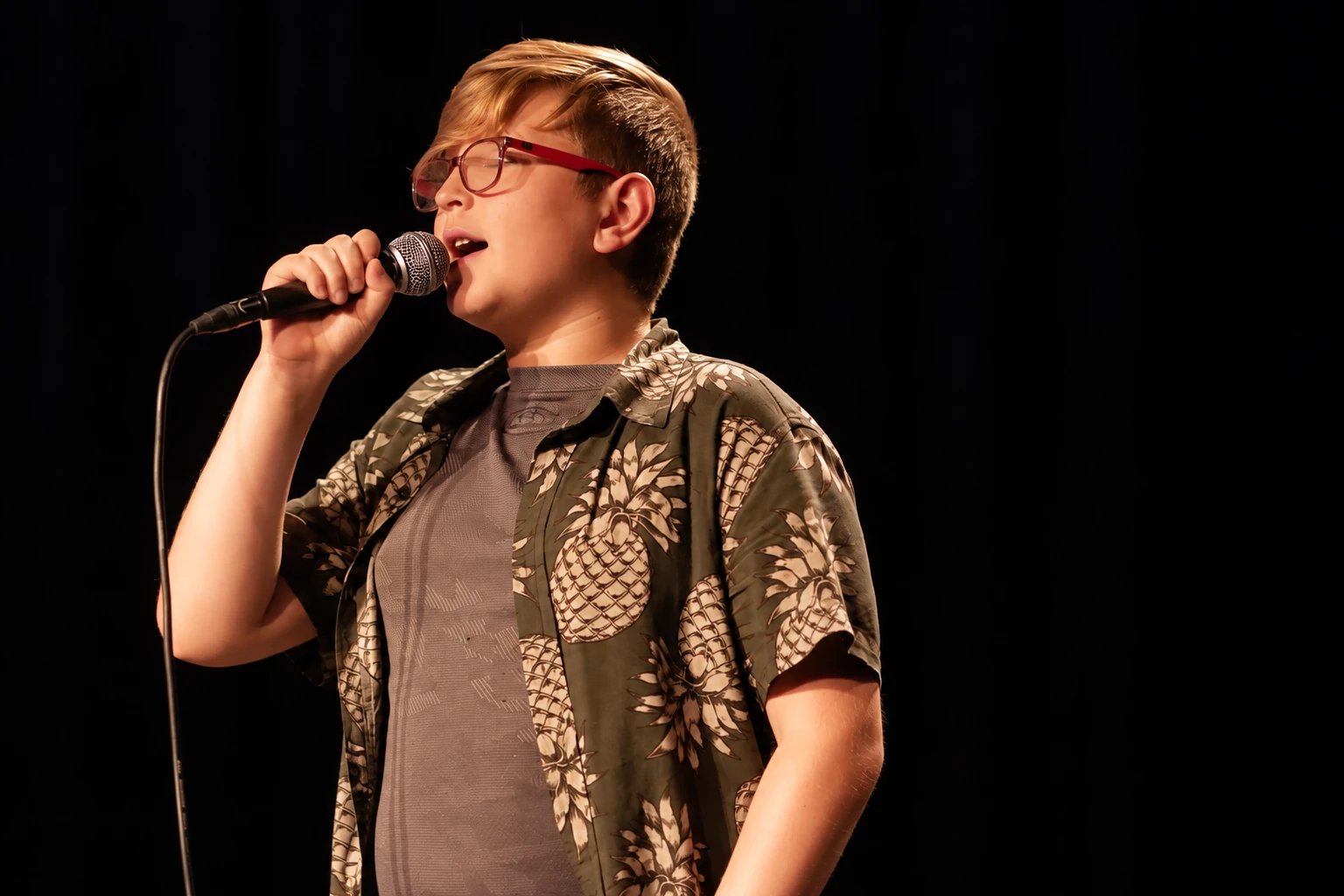 MBMS singer holding a microphone on an MBMS stage