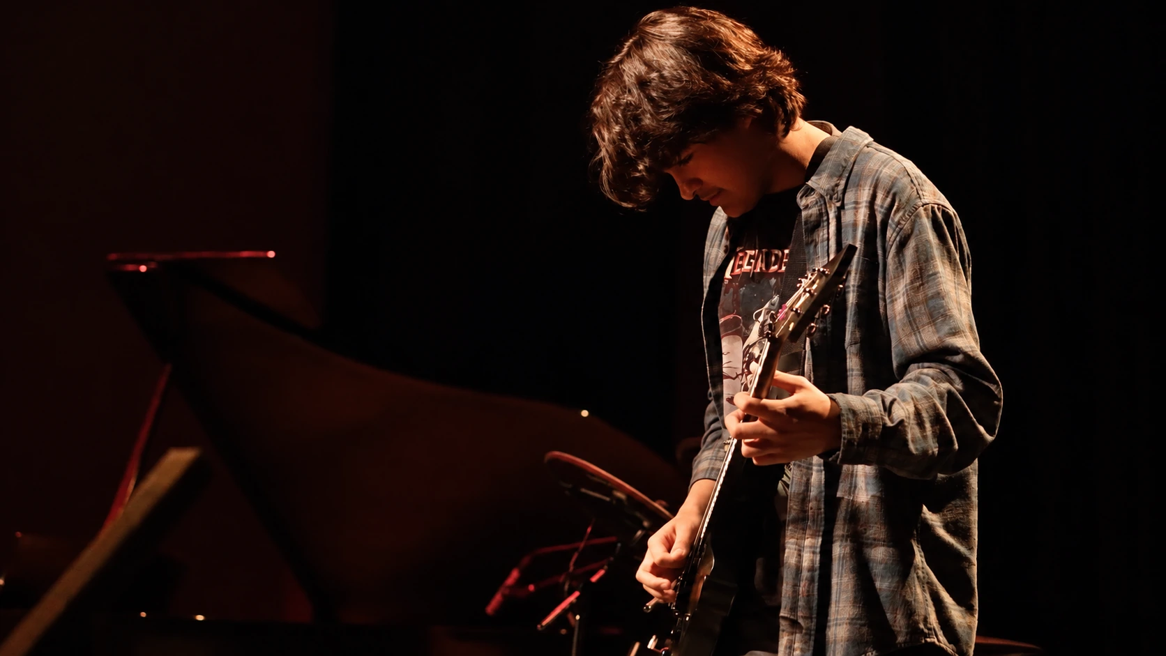 Guitarist looking down while playing an electric guitar