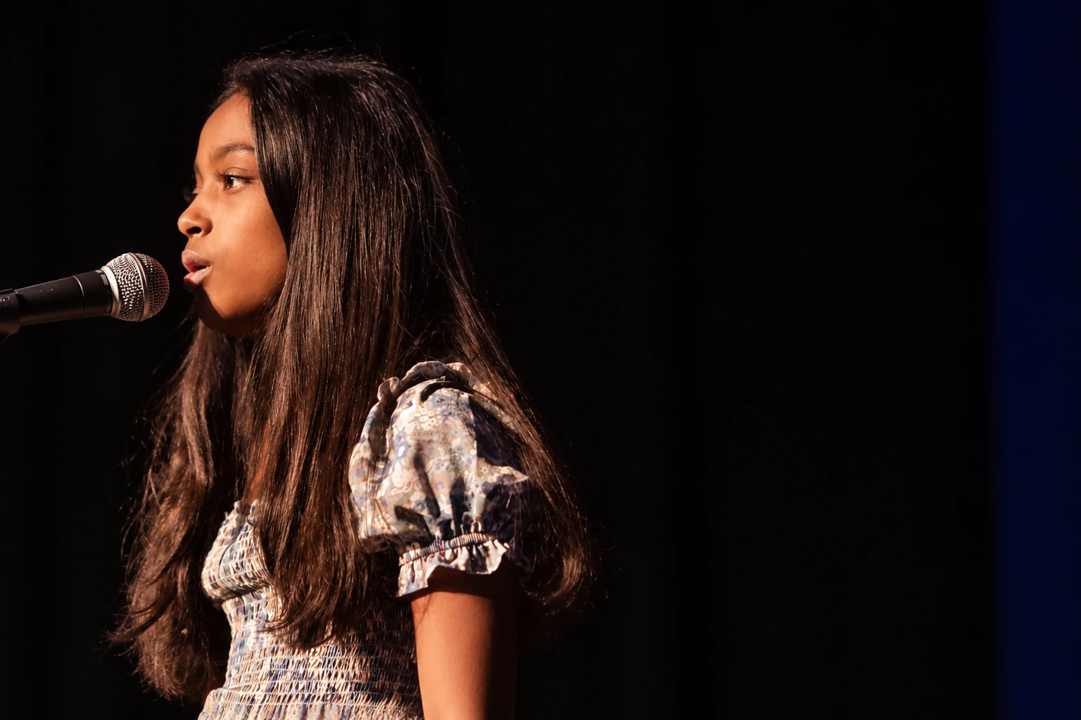 Student singer performing into a microphone