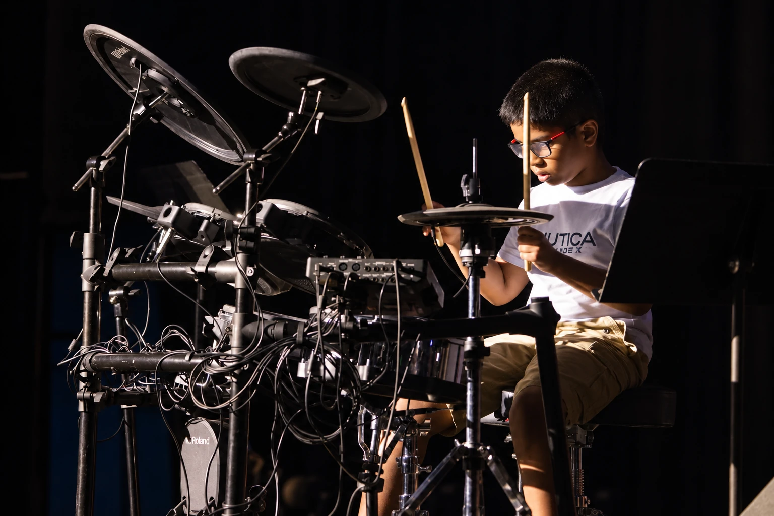 Teen musician playing drums on an MBMS stage